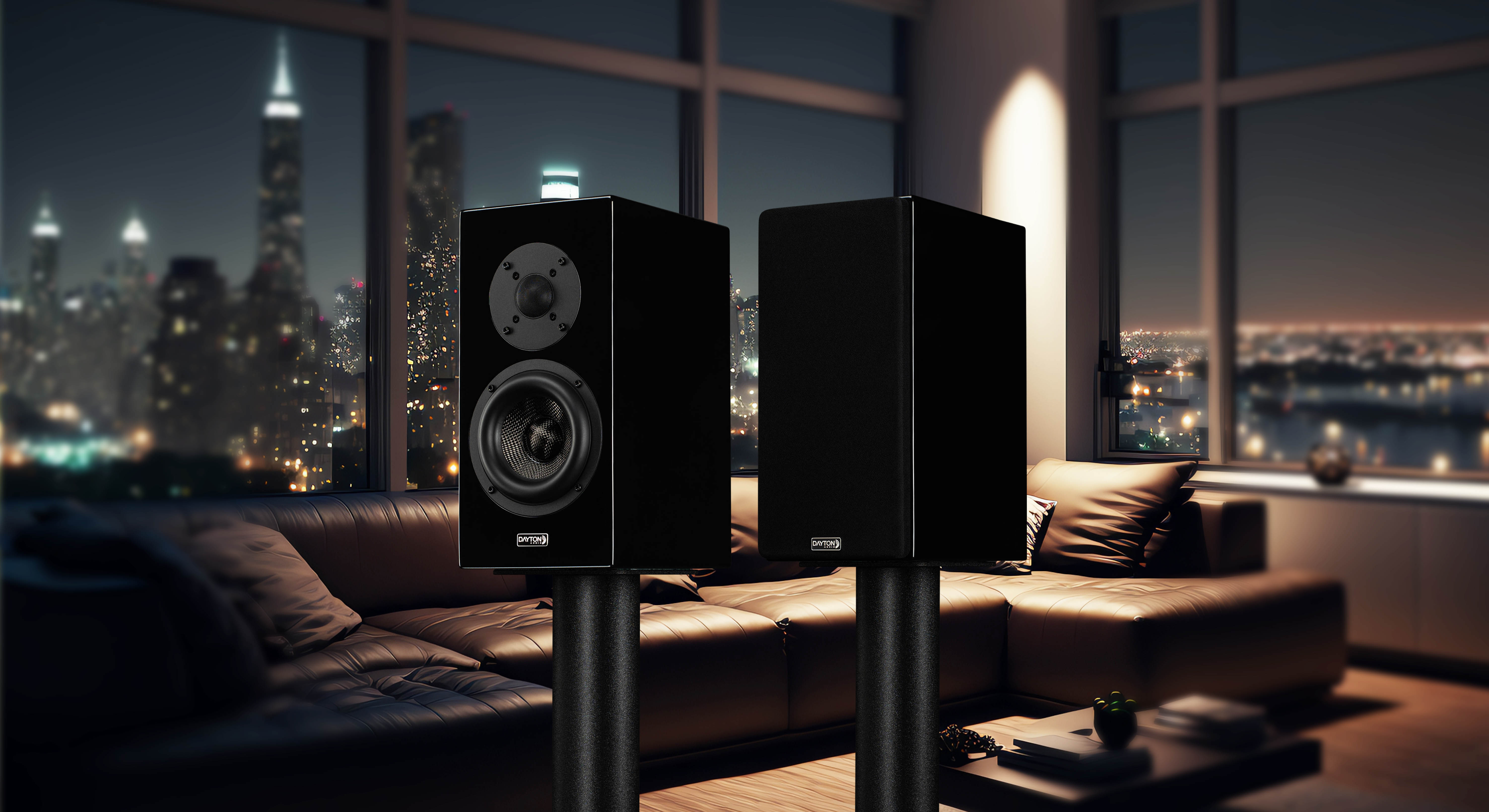 The black OPAL1 speakers *ONLY SOLD IN PAIRS* on a night cityscape background